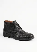 Bota corta tipo botineta de cuero negro con textura granulada, cierre mediante cordones y suela plana de goma.