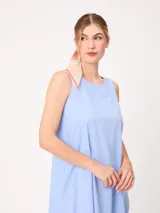 Vestido midi sin mangas de corte recto y holgado, color beige, con cuello redondo y bolsillos laterales.