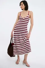 Vestido midi de tejido de punto con diseño de rayas horizontales en color bordó y blanco. Presenta escote en V, breteles finos ajustables y una silueta fluida y cómoda.