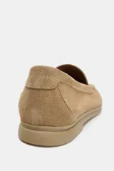 Mocasín plano de mujer confeccionado en serraje, con diseño de punta redonda, copete subido y suela con efecto engomado.