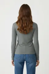 Polera blanca de algodón y elastano, corte ajustado y cuello alto.