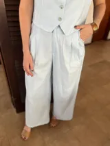 Pantalón sastrero celeste de lino, de corte ancho y tiro alto, con pinzas en la cintura y bolsillos laterales.