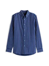 Camisa Tommy Hilfiger de corte regular, confeccionada en tejido Oxford de algodón con textura y diseño de rayas verticales azules y blancas. Cuenta con cuello abotonado, mangas largas con puños abotonados y logo bordado en el pecho.