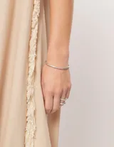 Vestido largo blanco de lino con escote en V y flecos de algodón en los bordes.