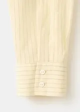 Camisa cruzada de manga larga con lazos para atar en la cintura y cuello camisero, con sutiles rayas verticales.