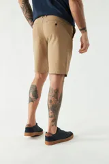 Bermuda de gabardina color gris claro, con bolsillos laterales y traseros.