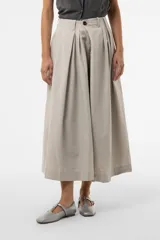 Pantalón wide leg de color blanco, de silueta amplia y gran movimiento, con pliegues delanteros que aportan volumen y estructura, y cintura definida.