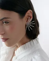 Caravanas tipo ear cuff con diseño de medio sol, compuestas por varillas metálicas plateadas, centro con strass y detalle de resina. Diseño liviano y brillante.