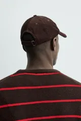 Gorra de seis paneles confeccionada en pana de algodón con visera curva y ajuste en la parte posterior.