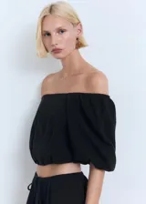 Falda larga evasé de tiro bajo y color negro, confeccionada en tejido 100% algodón, con cintura elástica y cordón ajustable.