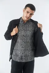 Sobrecamisa de jean color tostado, con cuello clásico, cierre frontal con botones y dos bolsillos frontales con solapa. Presenta mangas largas con puños abotonados y un pequeño parche decorativo en el ruedo.