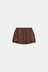 Falda pantalón de tiro medio con diseño tipo globo, confeccionada en tejido satinado color marrón. Presenta cintura elástica con cordones trenzados ajustables.