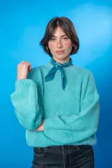 Sweater color beige de lana mohair y acrílico, con cuello redondo y mangas largas.