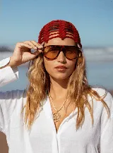 Casquete tejido a crochet en hilo de algodón color marrón, con diseño de red calada.