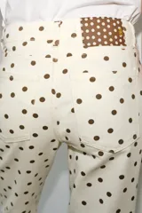Jeans de tiro medio con diseño de cinco bolsillos, corte mini flare y bajo evasé. Presenta un estampado de lunares en contraste.