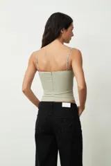 Top verde grisáceo con breteles finos y escote recto con detalle de encaje floral.