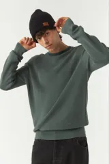 Sweater verde oscuro de punto con cuello redondo y mangas largas.