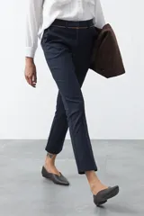 Pantalón de vestir negro de corte recto, con cintura estructurada y costura central vertical en las piernas que aporta un acabado sastrero.