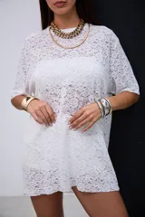 Remerón de encaje blanco con cuello redondo y mangas cortas.