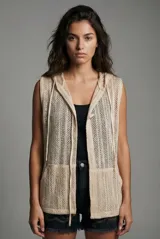 Chaleco de punto calado color beige, sin mangas, con capucha y bolsillos delanteros.