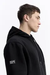 Canguro con capucha color verde oliva, de corte regular, con estampado gráfico multicolor en la espalda que incluye texto y formas abstractas.