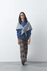Camisa de jean en tencel con silueta amplia, hombros caídos, cuello clásico y cierre frontal con botones. Presenta ruedo curvo con tajos laterales y pliegue en la espalda.