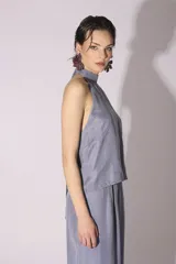 Blusa sin mangas color gris azulado, con cuello alto y escote halter.