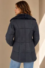 Campera de cuero babylamb color celeste, de corte recto y largo medio, con cuello de piel sintética y cierre frontal con botones.