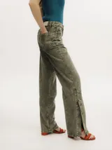 Pantalón de jean de corte recto y tiro medio, con efecto gastado. Presenta una hilera de botones en los laterales de los botapiés y bolsillos delanteros y traseros.
