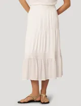 Falda larga de crepé de rayón color blanco, con diseño de paneles escalonados y detalles de puntilla. Presenta una silueta holgada y cintura elástica.