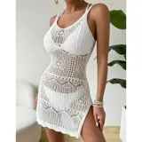 Vestido corto de playa color blanco, confeccionado en tejido calado con diseño geométrico y floral. Es de corte recto al cuerpo, sin mangas, con escote redondo y un tajo lateral.