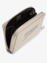 Billetera de poliuretano color beige con acabado liso, cierre de cremallera y dos compartimentos principales. Cuenta con el logo de Tommy Jeans texturizado en la parte delantera e insignia de la marca en el tirador.