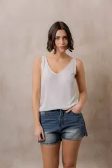 Musculosa de punto negro con efecto brillante, calce al cuerpo, escote en V y tirantes anchos.