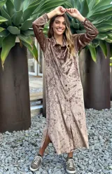 Vestido camisero largo de terciopelo color gris, con cuello camisero, manga larga y botones frontales. Presenta aberturas laterales en el ruedo.