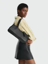 Cartera de hombro Longchamp modelo Looong, de diseño rectangular y minimalista en color negro. Presenta una estructura rígida, cierre superior y correas fijas para llevar al hombro con herrajes metálicos.