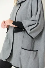 Chaquetón italiano rayado en tonos de natural y negro con vivos en negro. Modelo cruzado que se prende con un botón, amplios bolsillos delanteros y calce holgado.