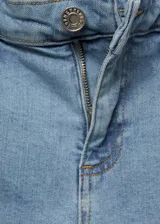 Jeans capri de corte skinny y tiro medio, confeccionados en tejido denim de algodón con elastano. Presentan costuras decorativas verticales en el frente, cierre de cremallera con botón, trabillas y bolsillos funcionales.