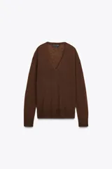 Jersey de punto color marrón chocolate, confeccionado en lana 100%, con escote en pico, manga larga y acabados en rib en puños y bajo.