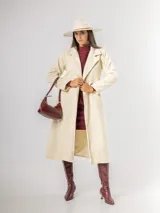 Tapado de paño sofisticado con solapas clásicas, cierre frontal de botones y bolsillos laterales. Presenta un diseño de corte recto y estructura elegante.