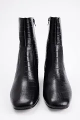 Bota de caña media con textura de reptil, color negro, con taco cuadrado bajo y punta redondeada.