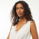 Blusa blanca sin mangas con escote en V y detalle de encaje en el borde.