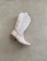 Botas de cuero color marrón y blanco con bordados negros, de estilo cowboy con taco bajo.