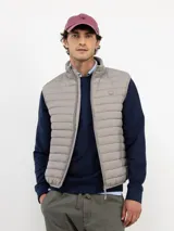 Chaleco acolchado de hombre confeccionado en nylon reciclado, con cierre frontal de cremallera, sisas elásticas y bolsillos laterales con cierre.