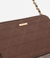 Cartera bandolera pequeña de textura granulada, con cierre superior de cremallera y correa de cadena entrelazada con material sintético. Presenta un diseño rectangular con placa metálica decorativa en el frente.