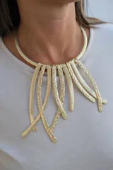 Collar rígido tipo gargantilla con diseño de tiras colgantes de metal dorado, que combinan superficies lisas y texturizadas.