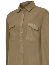 Camisa de manga larga color marrón claro, confeccionada en cotelé de algodón orgánico. Tiene cuello camisero, calce holgado, cierre frontal con botones a presión y dos bolsillos con solapa en el pecho.
