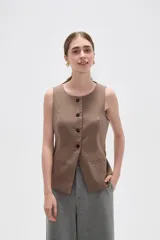 Chaleco sin mangas de corte sastrero, color marrón con diseño de rayas verticales finas. Presenta cuello redondo, cierre frontal con botones y dos bolsillos laterales simulados.