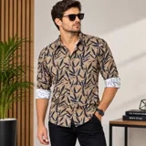 Camisa de manga larga de algodón color marrón con estampado de hojas oscuras y detalles en contraste blanco en el interior de los puños.