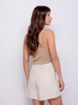 Short color crudo de tiro alto y corte holgado, con cuatro bolsillos, cierre frontal y elástico en la pretina trasera.