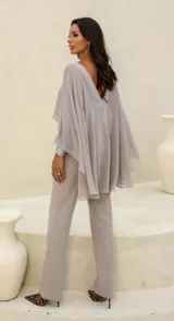 Conjunto color gris compuesto por un top corto con mangas anchas y un pantalón de vestir de tiro alto con bolsillos laterales.